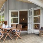 Deck with wooden table and chairs, open door to interior.