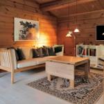Küche und Essbereich mit Holzwand und -decke, weißer Tisch, roter Teppich und Fenster.