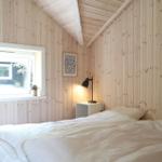 Küche mit Holzwänden und Dachboden. An der Wand hängen Bilder und ein Hut.