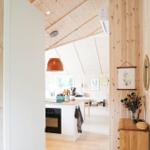 Holzwand mit Spiegel, Bildern und Schminktisch mit Blumen.