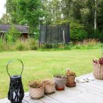 Terrasse mit zwei Rattan-Stühlen und einem Tisch. Durchgehende Glasfront zur Wohnung.