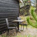 A dark-clad house with windows and a bench in the garden.