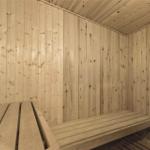 Badezimmer mit Dusche, Toilette und Waschbecken. Schwarze Fliesen und weiße Wände.