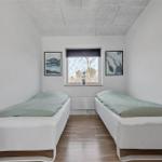 Schlafzimmer mit Bett, Fenster und zwei Wandbildern.