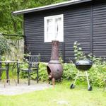 Außenbereich mit Tisch, Stühlen und Waschbecken an schwarzem Holzhaus