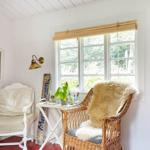 Ein Wohnzimmer mit blauem Sofa, Wandbild und Blick in das Esszimmer.