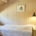 Badezimmer mit Holzwand, Waschbecken, Spiegel und Dusche.