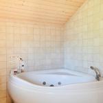 Bad mit Waschbecken, Spiegel und Handtuch an der Wand.