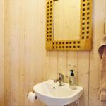 Schlafzimmer mit Holzwand, Bett, Kleiderschrank und Fenster zum Garten.