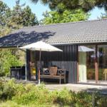 Terrasse mit Bank, Sonnenschirm und Blick in den Garten.