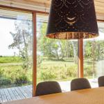 Wohnzimmer mit Sessel, Kamin und Wandbild. Holzfußboden und Stehlampe sichtbar.