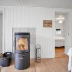 Schlafzimmer mit weißem Bett, Fenstern und Holzwandverkleidung.