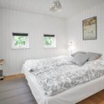 Schlafzimmer mit Bett, Fenster und Lampe.
