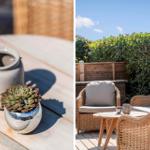 Terrasse mit Rattanmöbeln, Pflanzen und Tisch unter blauem Himmel.