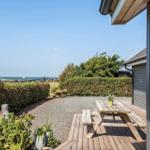 Terrasse mit Picknicktisch, Garten und Blick aufs Meer.