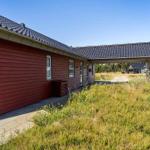 Grünes Gelände mit Spielplatz und Grill im Vordergrund. Im Hintergrund sind Bäume und Wasser sichtbar.