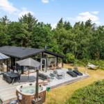 Moderne Villa mit großem Terrassenbereich, Whirlpool und Hängematten in grüner Umgebung.
