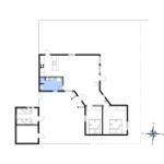 Luftbild einer Wohnsiedlung am Strand mit Feldern und Wäldern im Hintergrund.
