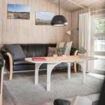 Schlafzimmer mit Holzwand, Bett und Fenster.