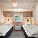 Sauna mit Holzwand, Holzbänken und einem Holzwaschbecken mit Deckel.