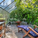 Terrasse mit Sitzbank, Pergola und Pflanzen im Garten