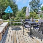 Terrasse mit Sitzbank, Pflanzen und Glasfront zur Wohnung.