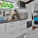 Badezimmer mit Dusche, Toilette, Waschmaschine und Fenster.