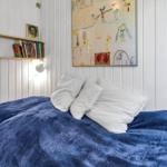 Schlafzimmer mit Bett, Fenstern und Gartenansicht.