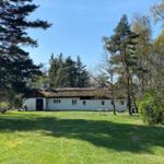 Roter Holzhaus mit Rasenfläche und Picknicktisch im Garten