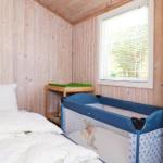 Küche mit Barhocker, Kühlschrank und Spiegel. Holzwände und Decke.