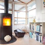 Esszimmer mit Holztisch, Sitzbank und Fenstern. Wandbilder und Deckenleuchte sichtbar.