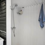 Cabin with open door, wooden wall, and anchor decoration.