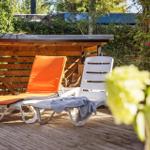 Backyard with wooden swing and climbing frame between trees.