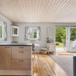 Kitchen with dining area and access to the garden. Wooden floor and white walls.
