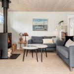 Living room with fireplace, sofa, and table. Wall painting and bookshelf visible.
