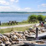 Two picnic tables by the water with view of green island.