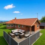 Rotes Ziegelhaus mit Terrasse, Garten und Meerblick.