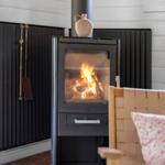 Essbereich mit Rattanstühlen und Holztisch an weißer Wand.
