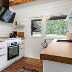 Essbereich mit Bambusstühlen und Holztisch. Durchgang in Wohnbereich mit Kamin und Terrasse.