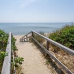 Strandhaus mit Blick aufs Meer und sonnigen Himmel.