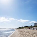 Strand mit Muscheln und Kies, Blick auf das Meer und den Himmel.