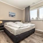 Schlafzimmer mit Doppelbett, Fenster und Wandbild