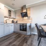 Moderne Küche mit Essbereich, Holzoptik und integriertem Ofen.