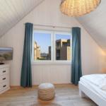 Zwei Schlafzimmer, Wohnbereich mit Sofa und Küche, Dusche und Toilette