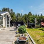 Esszimmer mit Tisch, Stühlen und Spielplatte. Große Fenster und Holzboden.