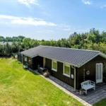 Ein Haus mit Terrasse, Whirlpool und Grillplatz im Grünen.