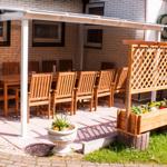 Terrasse mit Tisch, Stühlen und Blumenkästen unter Dach