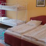 Zimmer mit Doppelbett, Schlafcouch und Klettertreppe. Wandfarbe gelb, Teppich mit Straßendesign.