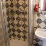 Duschbad mit Marmorfliesen, Waschbecken und Handtuchhalter