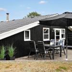Two black wooden houses with white window frames and door. Number 64 on one house.